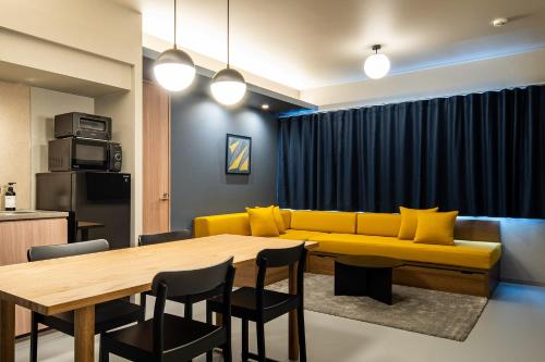 a living room with a yellow couch and a table at Section L Tsukiji in Tokyo
