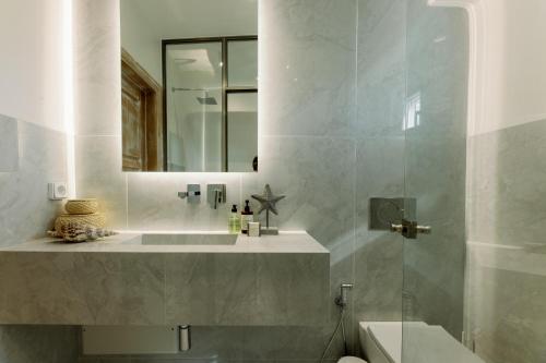 a bathroom with a sink and a mirror at Athina Studios and Suites Plaka in Plaka