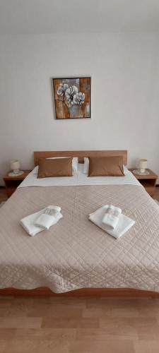 a bedroom with a large bed with two towels on it at Pahljina Apartments in Rab
