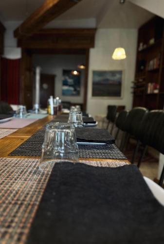 a long table with black mats and glasses on it at Agora Bed & Breakfast in Vlorë