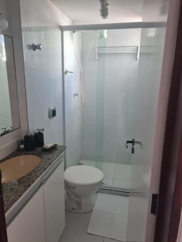 a bathroom with a toilet and a glass shower at Manaíra Flat 206 Em frente ao shopping Manaíra in João Pessoa