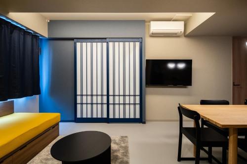 a room with a bed and a table and a window at Section L Tsukiji in Tokyo