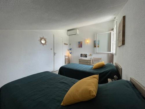 2 Betten in einem Zimmer mit grüner Bettwäsche und gelben Kissen in der Unterkunft Villa Saint-Cyprien, 3 pièces, 6 personnes - FR-1-106-26 in Saint-Cyprien