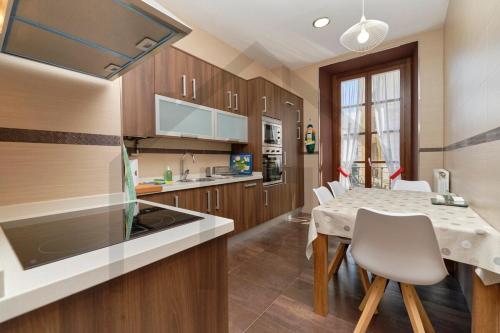 a kitchen with a table and a dining room at El pixin - Apartamento de gran categoría en GIJON in Gijón