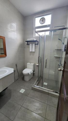 a bathroom with a shower and a toilet and a sink at Comfort Inn in Kampong Selayun
