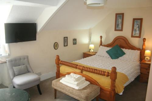 a bedroom with a large bed and a chair at Coynant Farm Guesthouse - Farm Park Stay in Swansea