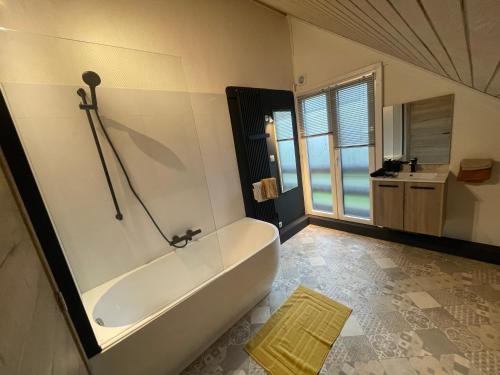 La salle de bains est pourvue d'une baignoire et d'un lavabo. dans l'établissement Gîte Le Pti Chouta, à Anhée