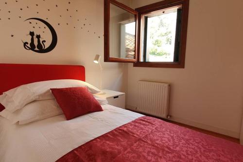 1 dormitorio con 1 cama con cabecero rojo y ventana en Flaminio's Suite Vittorio Veneto, en Vittorio Veneto