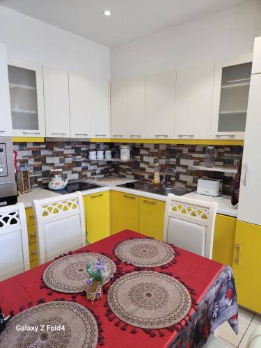 a kitchen with yellow and white cabinets and a table at A&K Sea View Apartament 6 in Durrës