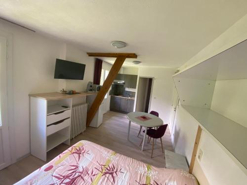 a bedroom with a bed and a desk and a table at Appart Le Chili- Quartier thermal- Parc remarquable - Linge fourni in Luz-Saint-Sauveur