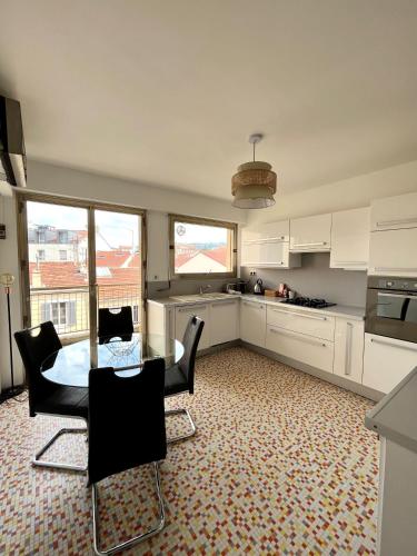 une cuisine avec une table et des chaises dans une pièce dans l'établissement Central -300m Palais- Seaview-A/C-WIFI-spacieux, à Cannes