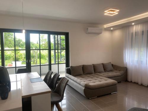 a living room with a couch and a table at Terra Toscana Apartman in Sárvár