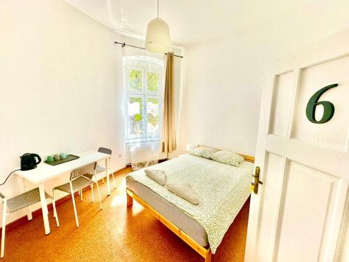 a bedroom with a bed and a table and a window at Atlas' House in Poznań