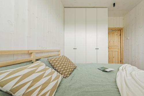 Un dormitorio con una cama con un libro encima. en Svencelės burė 2, en Svencelė