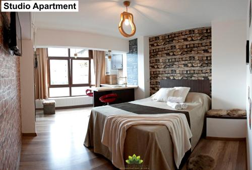 um quarto com uma cama e uma parede de tijolos em Sibiu Lotus Apartments em Sibiu