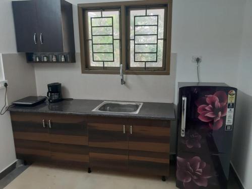 a small kitchen with a sink and a refrigerator at Coral Drive Villas -Your Private Beach Destination in Chennai