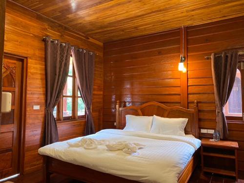 a bedroom with a bed in a wooden room at Konglor Cave Resort in Ban O