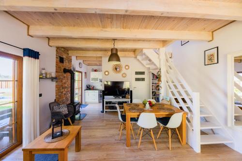 a dining room and living room with a table and chairs at DOMEK LUKSUSOWY KASZUBSKA OSTOJA in Barkocin