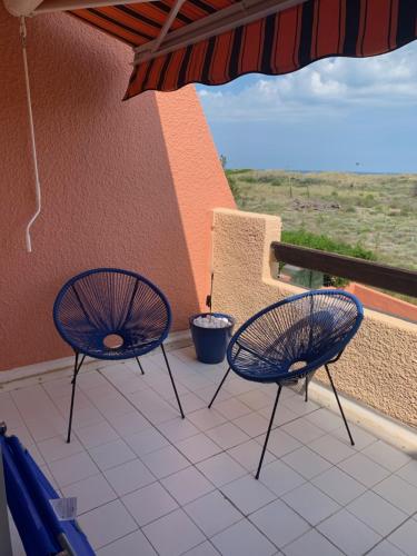 2 sillas en un balcón con vistas al océano en Mon Petit Paradis, vue sur dunes et mer, accès direct plage Robinson, terrasse, parking privé, très ressourçant, à Marseillan Plage, en Marseillan