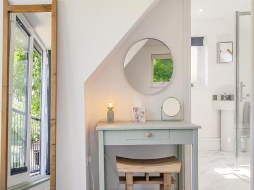 een kaptafel in een badkamer met een spiegel bij South Wood Lodge in Slindon