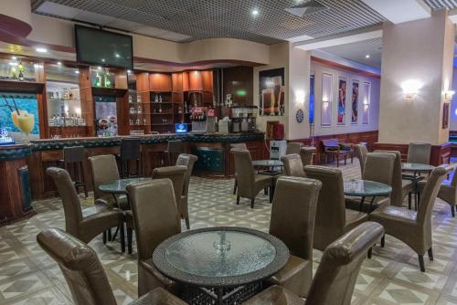 a restaurant with tables and chairs and a bar at Dexon Roma Hotel in Hurghada