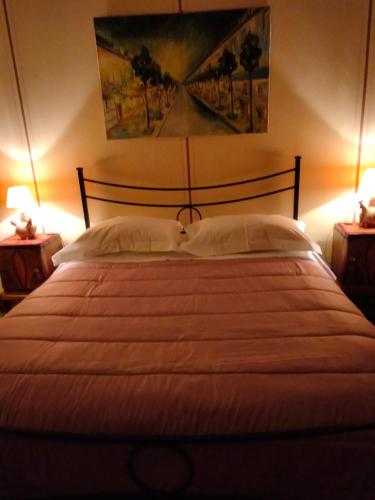 a bedroom with a large bed with two night stands at Bed and Breakfast Su Niu in Quartucciu
