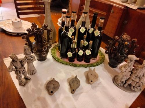 a table with bottles of wine and some figurines on it at Bed and Breakfast Su Niu in Quartucciu