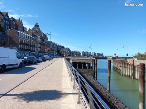 une rue avec des voitures garées sur un trottoir à côté de l'eau dans l'établissement LE TREPORT 60M2 à 2mn plage port funiculaire casino commerces, au Tréport