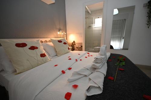 a bedroom with a white bed with red flowers on it at HB Torrevieja in Torrevieja