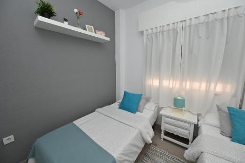 a small bedroom with two beds and a couch at HB Torrevieja in Torrevieja