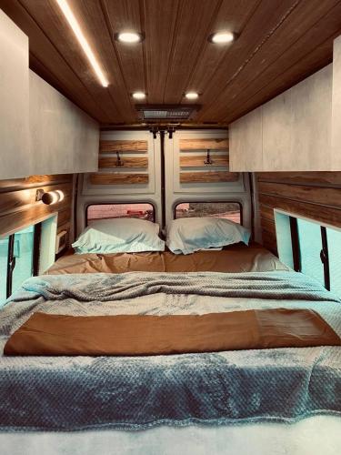ein großes Bett im hinteren Teil eines Wohngebäudes in der Unterkunft best camper van in tbilisi in Tbilisi City