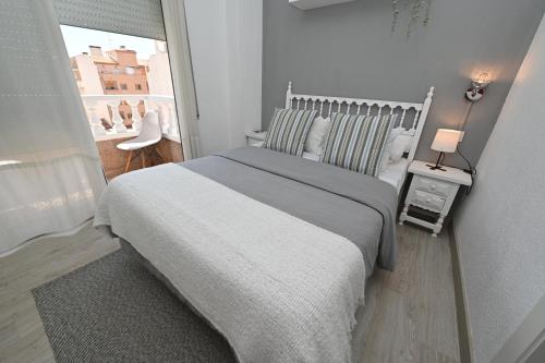 a bedroom with a large bed and a window at HB Torrevieja in Torrevieja