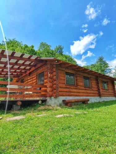 drewniany domek z ławką w trawie w obiekcie Відпочинок у Закарпатті w mieście Kushnytsya