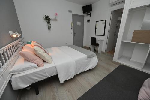 a bedroom with a bed with pillows on it at HB Torrevieja in Torrevieja