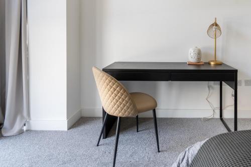 a black desk with a chair next to a bed at Hemel Apartments- City Zen in Hemel Hempstead