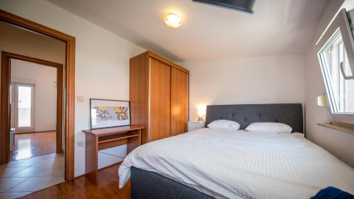 een slaapkamer met een groot bed en een houten kast bij Apartment Lapad in Dubrovnik
