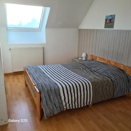 1 dormitorio con 1 cama con manta a rayas en blanco y negro en chez charly et jo, en La Suze-sur-Sarthe