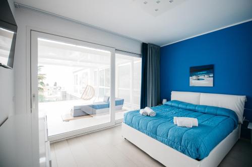 a blue bedroom with a bed and a balcony at Diana - Taormina Minerva Luxury Apartment by Taormina Holidays in Taormina