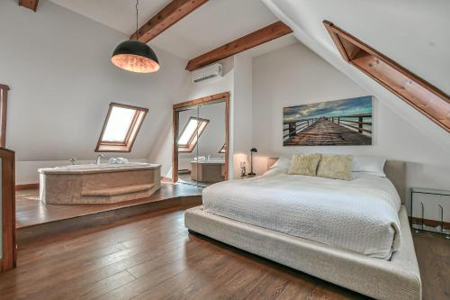 a bedroom with a large bed and a bath tub at Panorama in Sainte Anne des Lacs