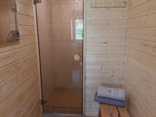 W łazience znajduje się prysznic ze szklanymi drzwiami. w obiekcie Otsa puhkemaja w mieście Raudsepa