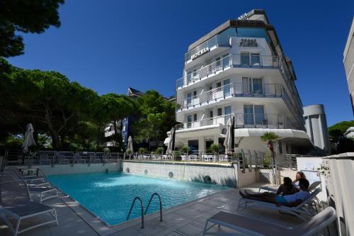 un hotel con piscina frente a un edificio en Grand Hotel Playa, en Lignano Sabbiadoro