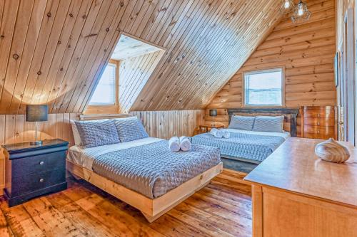 sypialnia z 2 łóżkami w drewnianym domku w obiekcie River Rock Retreat w mieście Notre-Dame-de-la-Merci