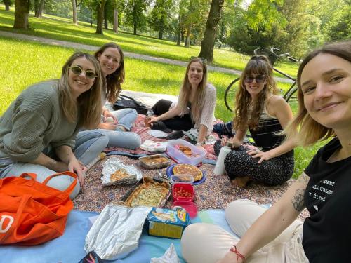 a group of women sitting on a picnic blanket at Karma Hostel in Khajurāho