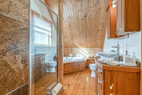 a bathroom with a shower and a toilet and a sink at River Rock Retreat in Notre-Dame-de-la-Merci