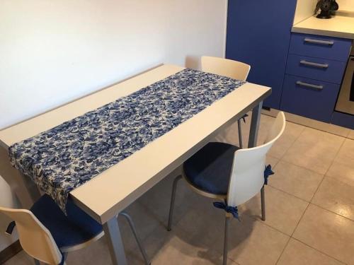 uma mesa numa cozinha com cadeiras à volta em Confortevole Appartamento ad Aviano em Aviano