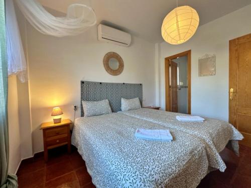 1 dormitorio con 1 cama con 2 toallas en Villa Liviana, Piscina Barbacoa y preciosas vistas Málaga by CostaDelSolEscapes en Cómpeta