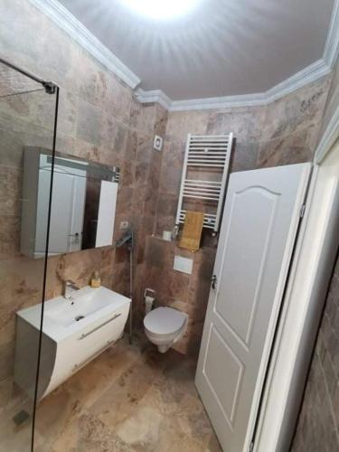 a bathroom with a toilet and a sink and a mirror at My home - Unique Luxury in Năvodari