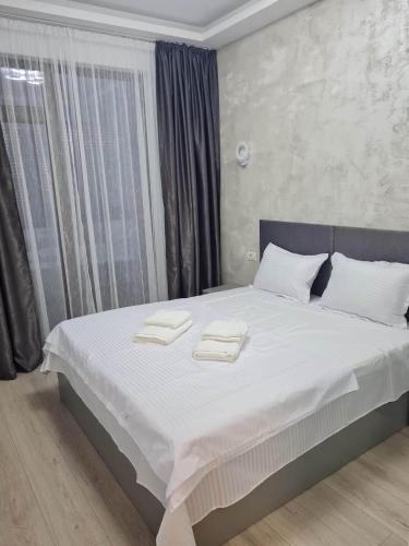 a bedroom with a bed with two towels on it at My home - Unique Luxury in Năvodari