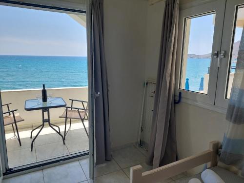 a room with a view of the ocean from a balcony at Giant Woman in Tsoútsouros