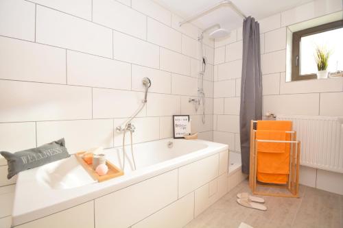 ein weißes Badezimmer mit einer Badewanne und einem Waschbecken in der Unterkunft GUN01-RI Apartment in Haundorf in Haundorf